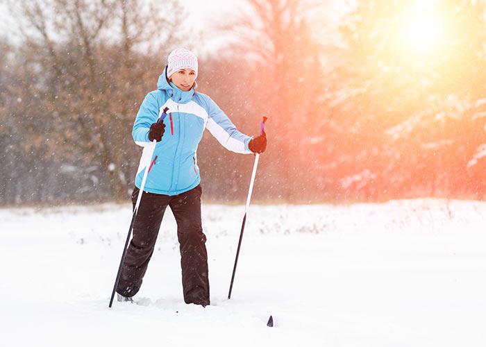 Young woman cross-country skiing in winter park