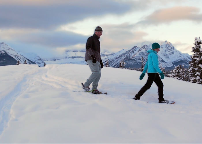 Couple on top of mountain snowshoeing