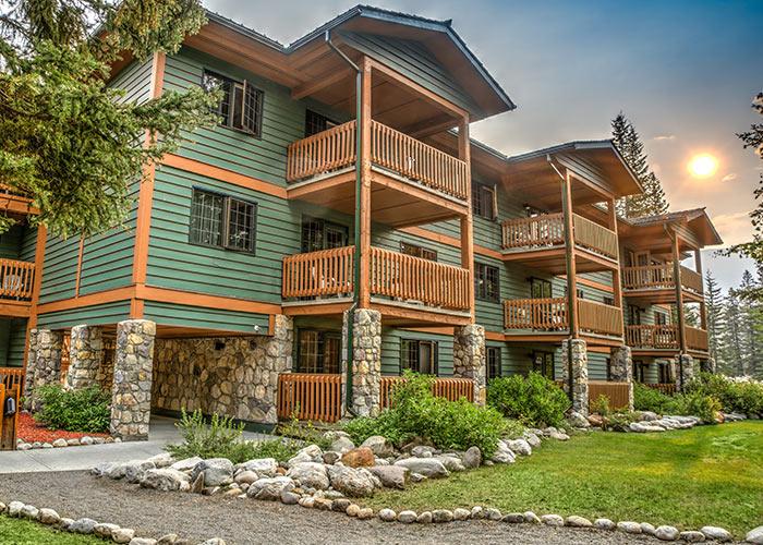 Exterior shot of lodging building with rock lined paths and landscaped areas of grass
