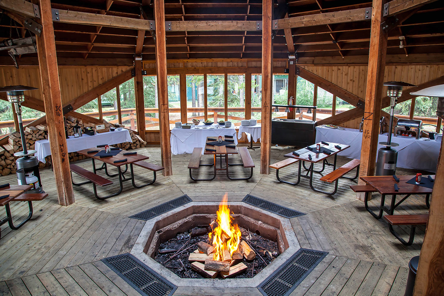 Interior of Great Canadian Gazebo with warming fire and tables set for dinner