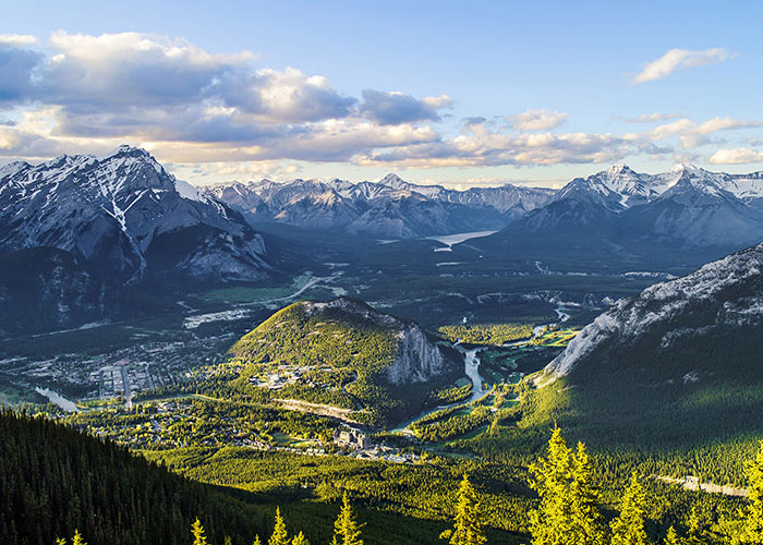 The setting Sun casting golden rays on the town of Banff in Alberta, Canada, taken from Sulphur Mountain