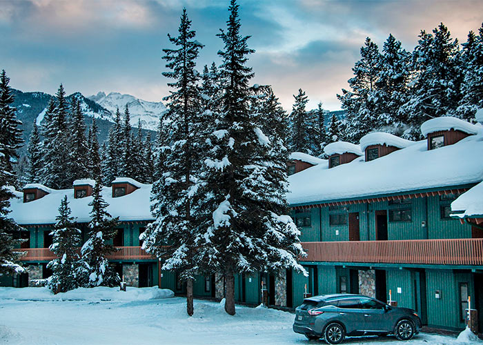 Exterior of one of the lodgings at the Lake Louise Inn, car parked next to room