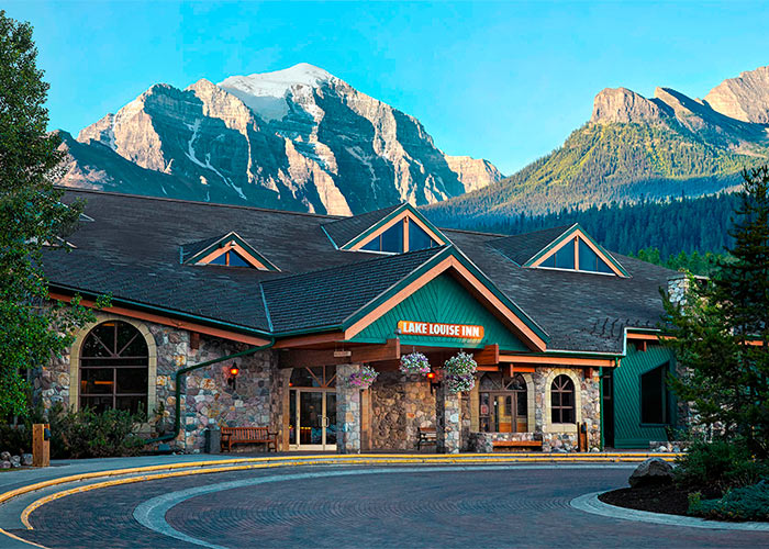 Exterior of reception building at the Lake Louise Inn surrounded by mountains