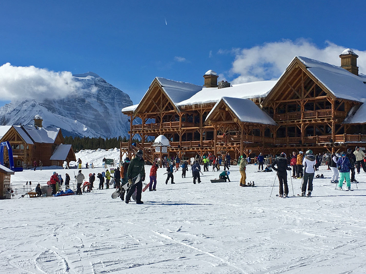 Lake Louise Ski Resort Lodge in winter with lots of skiers and boarders getting ready to go up lift