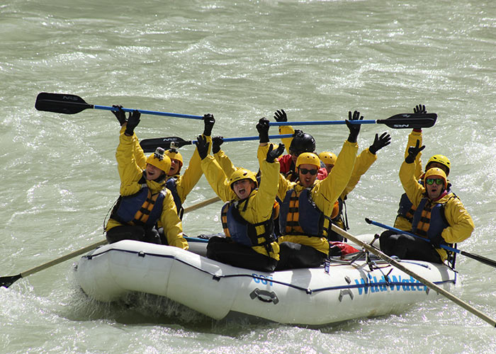 Group of rafters cheering after going through rapids on Kicking Horse River
