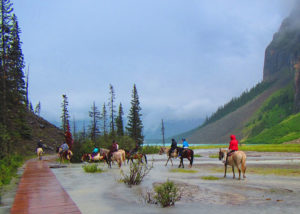 Group on horses traveling through flooder area to mountain trail