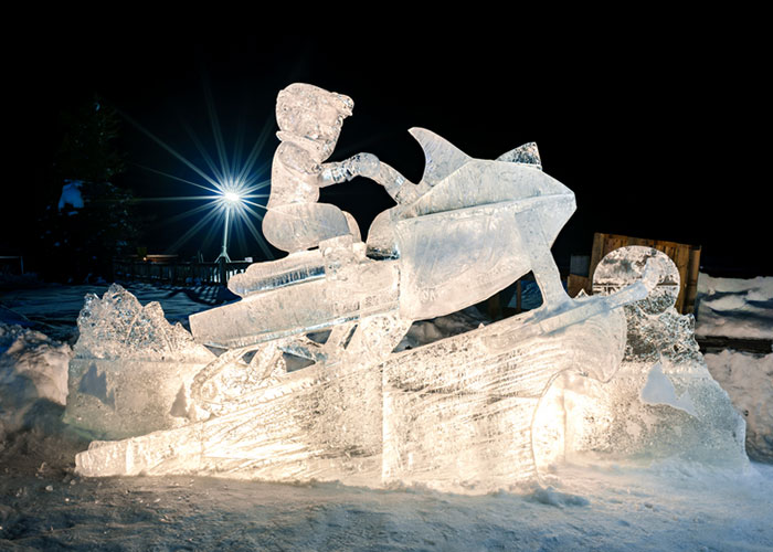 Ice sculpture of a child in a snowmobile
