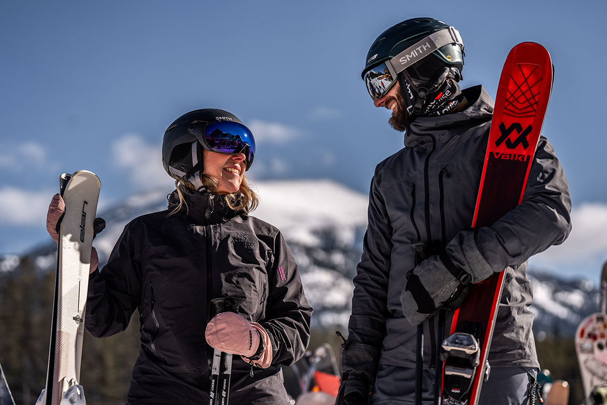 Couple in ski gear holding snowboards