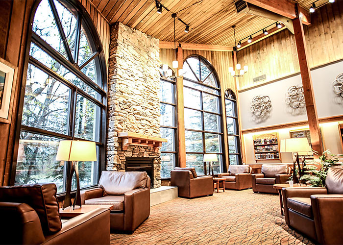 Leather couches in Lake Louise Inn lobby with rock fireplace and local art