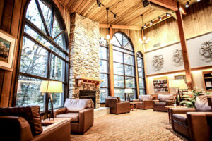 Leather couches in Lake Louise Inn lobby with rock fireplace and local art